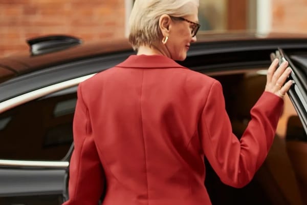 Chauffeur opening luxury black car door curbside